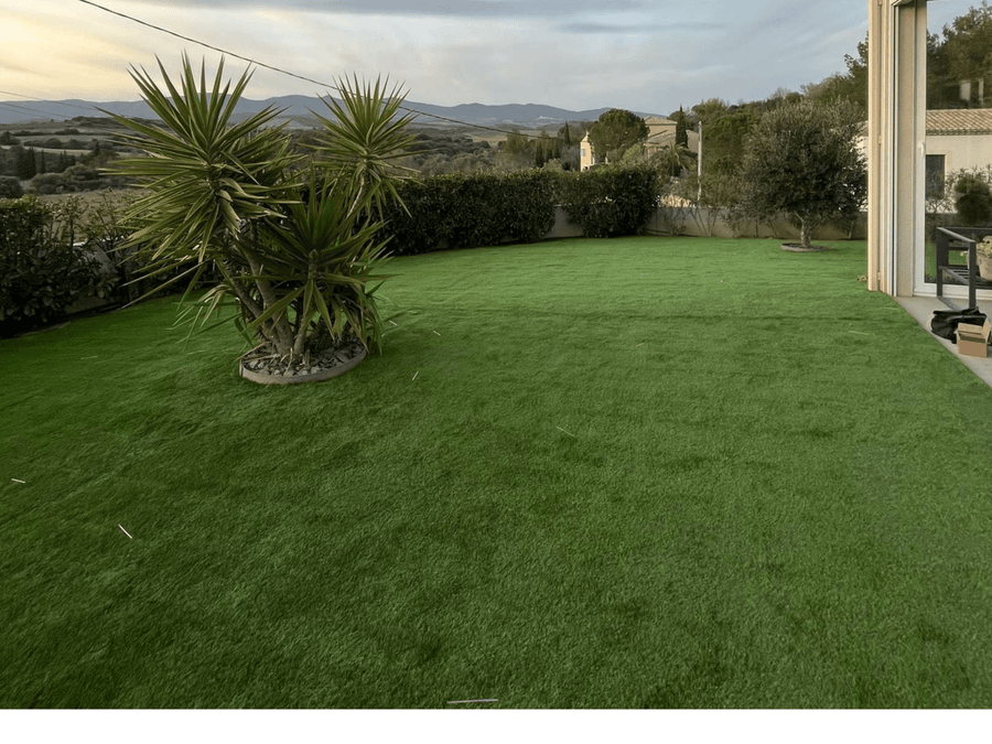 Gazon synthétique Cannes 40 mm posé dans un jardin ouvert sur la campagne