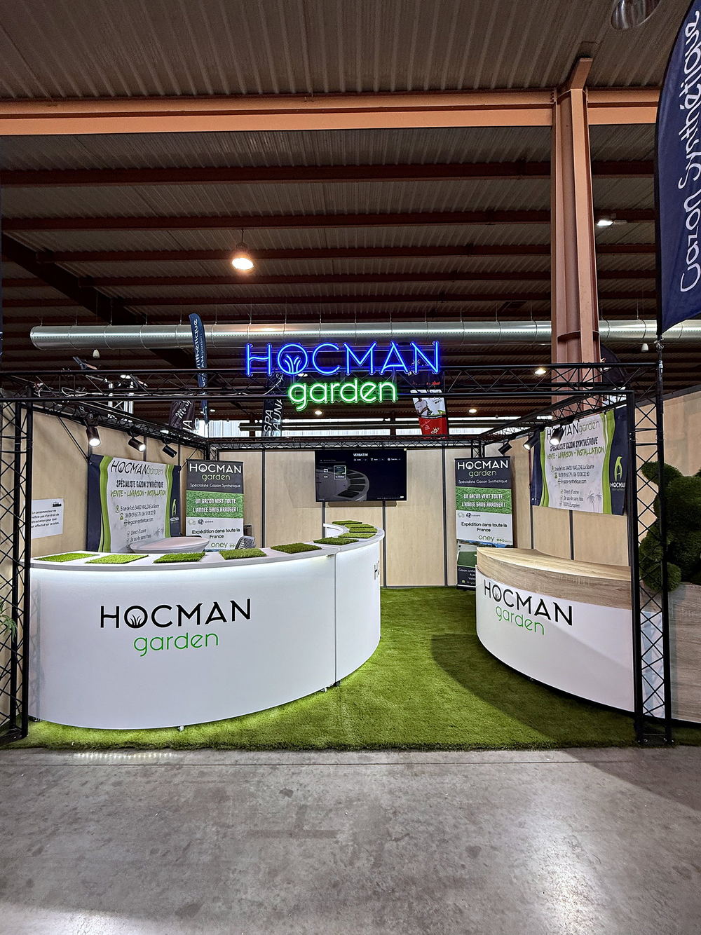 Comptoir d'accueil du stand Hocman Garden et allée en gazon synthétique